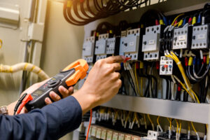 Electricians hands working on a residential electric box.