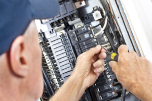 Electrician doing electrical work in breaker box.